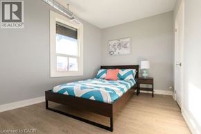 Hamilton apartment for rent - A bedroom with a bed, nightstand, and window.