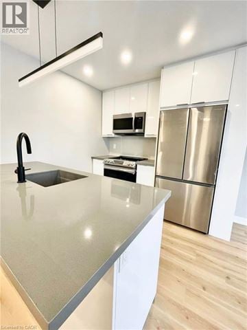 Hamilton apartment for rent - A modern kitchen with a stainless steel refrigerator and a sink with a black faucet.