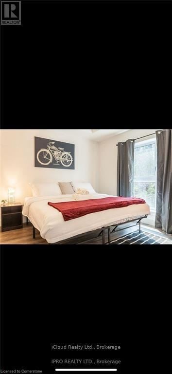 Kitchener condo for rent - A bedroom with a white bed and a bicycle picture on the wall.