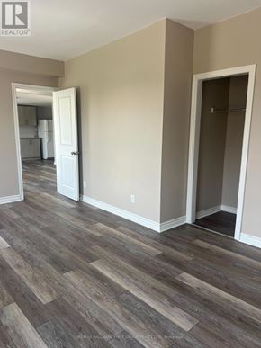 Oshawa (Lakeview) multi-family for rent - A room with a wooden floor and a doorway leading to another room.