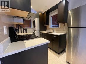 Vancouver apartment for rent - A modern kitchen with a stove top oven and a refrigerator.
