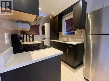 Vancouver apartment for rent - A modern kitchen with a stove top oven and a refrigerator.