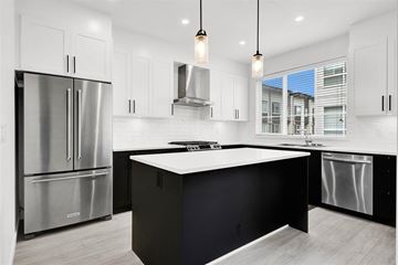 Surrey townhouse for rent - A modern kitchen with a large island and stainless steel appliances.
