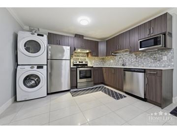 Surrey apartment for rent - A kitchen with a washer and dryer built into the cabinetry.