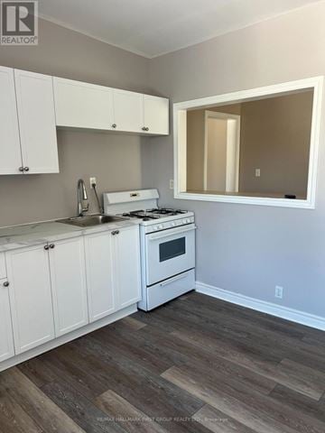 Oshawa (Lakeview) multi-family for rent - A kitchen with white cabinets and a white stove top oven.