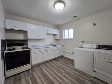 East Chicago apartment for rent - A kitchen with white cabinets and a black oven.