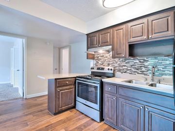 Jacksonville apartment for rent - A kitchen with wooden cabinets and a stone backsplash.