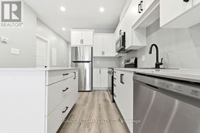 Bonnechere Valley apartment for rent - A modern kitchen with white cabinets and stainless steel appliances.