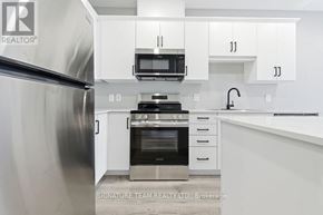 Bonnechere Valley apartment for rent - A kitchen with white cabinets and stainless steel appliances.