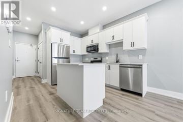 Bonnechere Valley multi-family for rent - A modern kitchen with white cabinets and stainless steel appliances.
