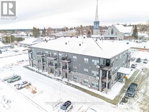 Bonnechere Valley multi-family for rent - A large grey building with a steeple in the background.