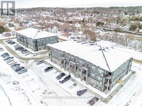 Bonnechere Valley multi-family for rent - A large grey building with a parking lot in front of it.