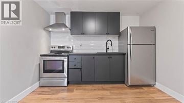 Brantford apartment for rent - A modern kitchen with a stainless steel refrigerator and a stove top oven.
