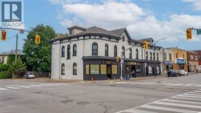 Brantford apartment for rent - A street view of a building with a Realtor sign in the corner.