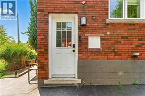 Hamilton apartment for rent - A red brick house with a white door and a small window above it.