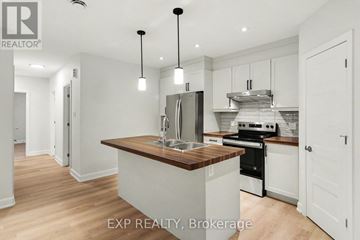 Russell apartment for rent - A modern kitchen with white cabinets and a wooden island.