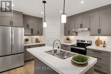 Russell apartment for rent - A modern kitchen with a stainless steel refrigerator and a central island with a sink.