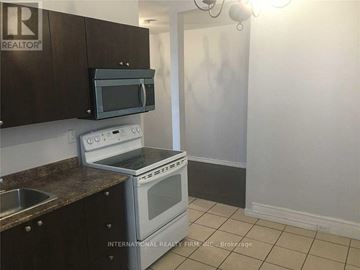 Toronto (Moss Park) apartment for rent - A kitchen with a stove top oven and microwave above it.