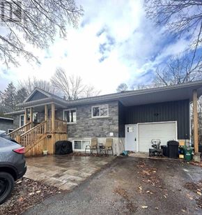 Orillia apartment for rent - A grey house with a garage and a driveway.
