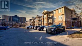 Barrie (Sunnidale) condo for rent - A parking lot with cars and apartment buildings in the background.