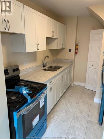 Windsor townhouse for rent - A kitchen with a blue stove top oven and white cabinets.