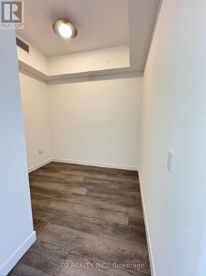 Toronto (Centennial Scarborough) condo for rent - A room with a wooden floor and white walls.