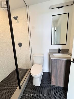 Toronto (Centennial Scarborough) condo for rent - A white toilet in a small bathroom with a sink and mirror.