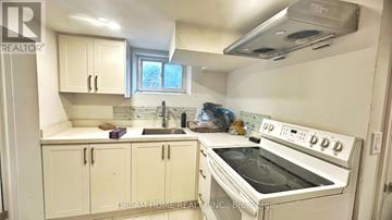 Toronto (Ionview) apartment for rent - A white kitchen with a stove top oven and cabinets.