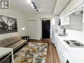 Waterloo condo for rent - A modern kitchen with white cabinets and a floral rug on the floor.