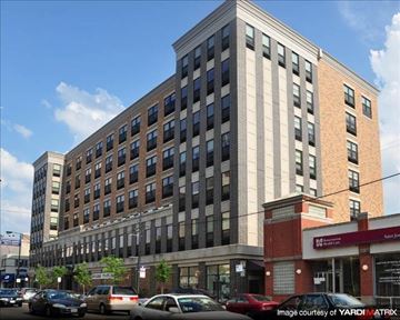 Chicago apartment for rent - a tall building with cars parked in front of it
