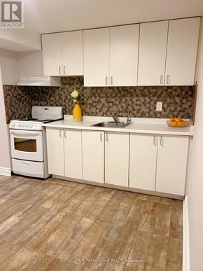 Toronto (Humewood-Cedarvale) apartment for rent - A kitchen with white cabinets and a tiled backsplash.
