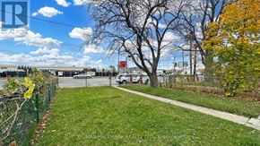 Toronto (Downsview-Roding-Cfb) apartment for rent - A view of a green lawn with a fence and trees.