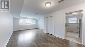 Toronto (Downsview-Roding-Cfb) apartment for rent - A spacious room with a window and a door leading to another room.