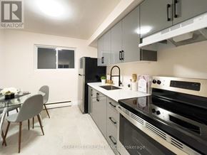 London East (East M) multi-family for rent - A modern kitchen with a glass table and chairs, a refrigerator, and a stove top oven.