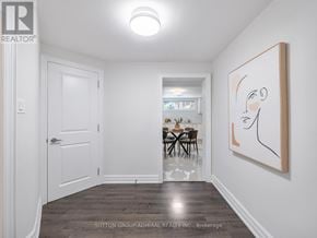 Toronto (Bathurst Manor) apartment for rent - A room with a white door, a dining table with chairs, a painting on the wall, and a wooden floor.
