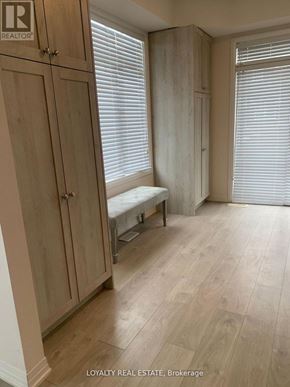 Clarington (Bowmanville) townhouse for rent - A room with wooden floors and a bench in front of a window.