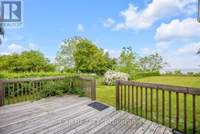 Port Hope apartment for rent - A wooden deck with a railing and a view of a grassy area.