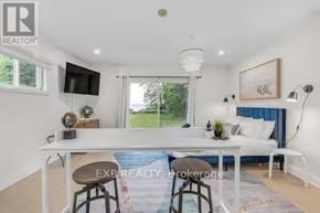 Port Hope apartment for rent - A white dining table with a blue cushion and a white sofa with a blue cushion in the background.