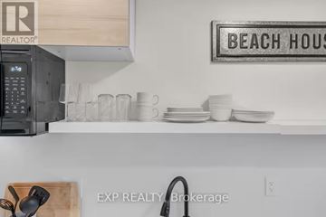 Port Hope apartment for rent - A kitchen counter with a sign that says "BEACH HOUSE" on the wall.