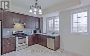 Toronto (Cliffcrest) townhouse for rent - A kitchen with dark wood cabinets and stainless steel appliances is on the market.