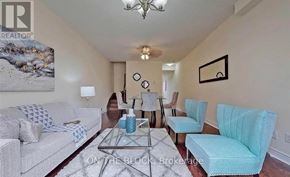 Toronto (Cliffcrest) townhouse for rent - A living room with a grey couch, a glass table, and a painting on the wall.