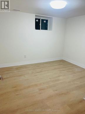 Oshawa (Lakeview) apartment for rent - A room with a wooden floor and a white wall with a small window.