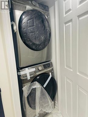 Oshawa (Lakeview) apartment for rent - A washer and dryer in a small laundry room.
