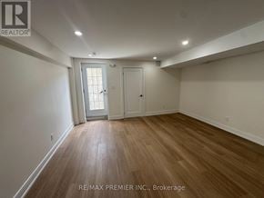 New Tecumseth (Tottenham) apartment for rent - A room with wooden flooring and white walls, with a door and a window.