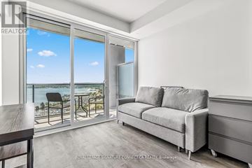 Barrie (City Centre) condo for rent - A living room with a grey couch and a table.