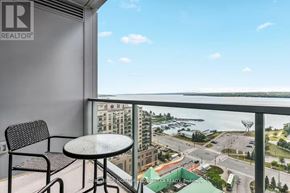 Barrie (City Centre) condo for rent - A balcony with a table and chairs overlooking a city street.