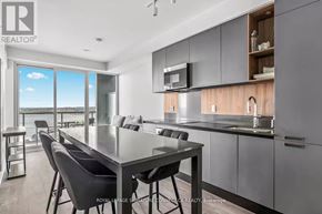 Barrie (City Centre) condo for rent - A modern kitchen with a dining table and chairs.