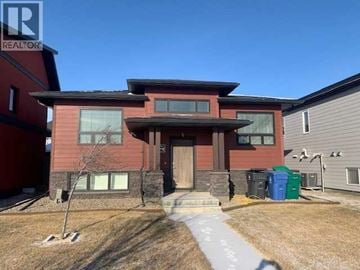 Lethbridge apartment for rent - A red house with a brown roof and a grey garage door.