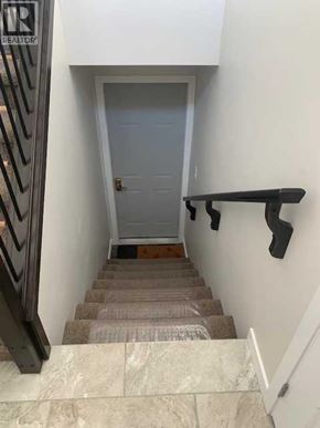 Lethbridge apartment for rent - A stairway with a carpeted runner and a black handrail.