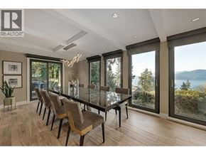 Lions Bay apartment for rent - A realtor logo is on a picture frame in a well-lit room with a long table and chairs.